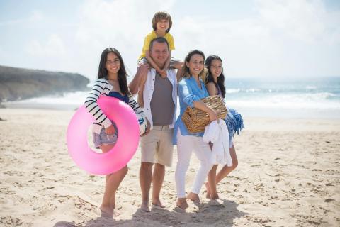 family-sitting-on-the-beach-photo by Kampus Product