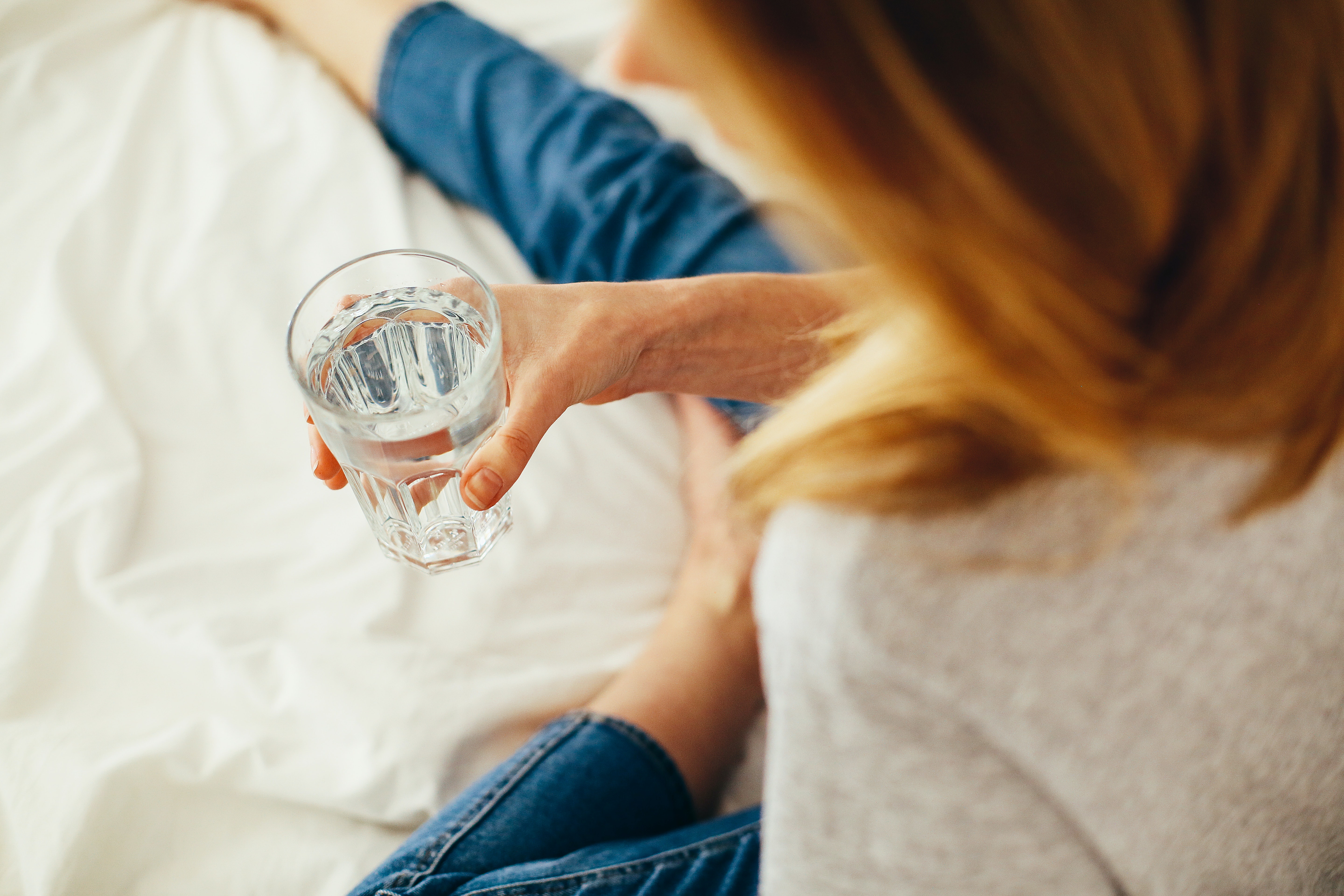 women holding glass of water