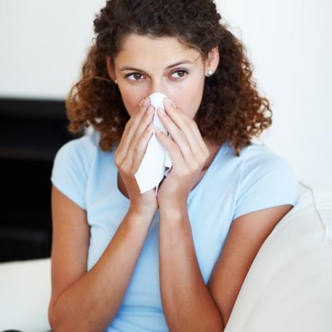 Woman blowing her nose